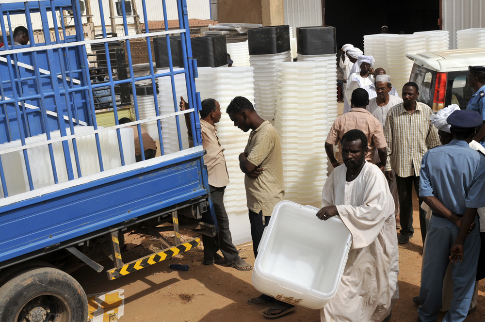 Lifting ballot boxes onto truck.