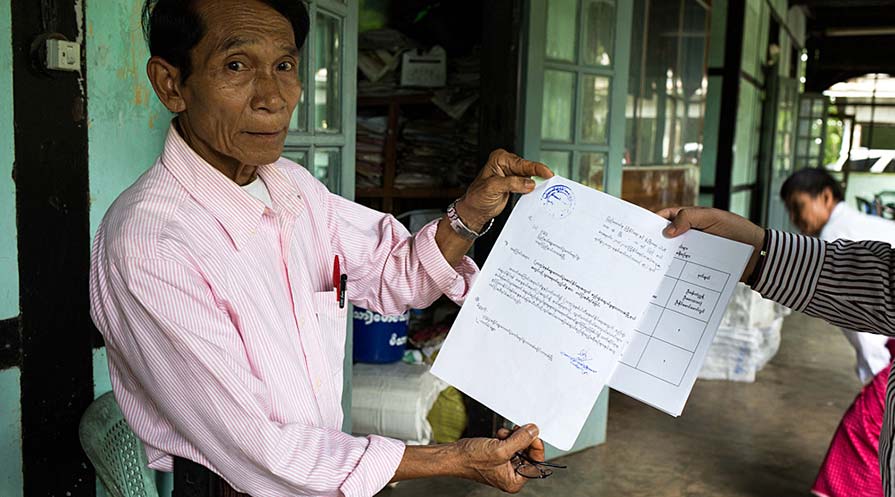 Photo of an office clerk holding up a campaign plan.