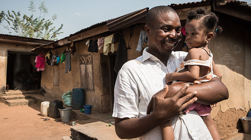 Gabriel Ani cuddles his daughter near their home.