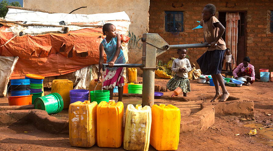 Children are collecting water from a well in the district of Ruashi, in Lubumbashi, DRC.