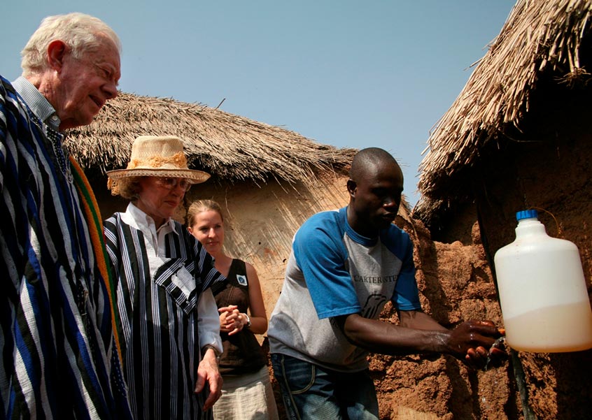 Health worker Fusheni Nazeed demonstrates for President and Mrs. Carter how trachoma can be prevented when simple environmental strategies and health education become part of people's daily lives in the village of Tingoli, Ghana, in 2007. Ghana is the first sub-Saharan African country to be validated by the World Health Organization for eliminating the eye disease trachoma as a public health problem. (Photo: The Carter Center)